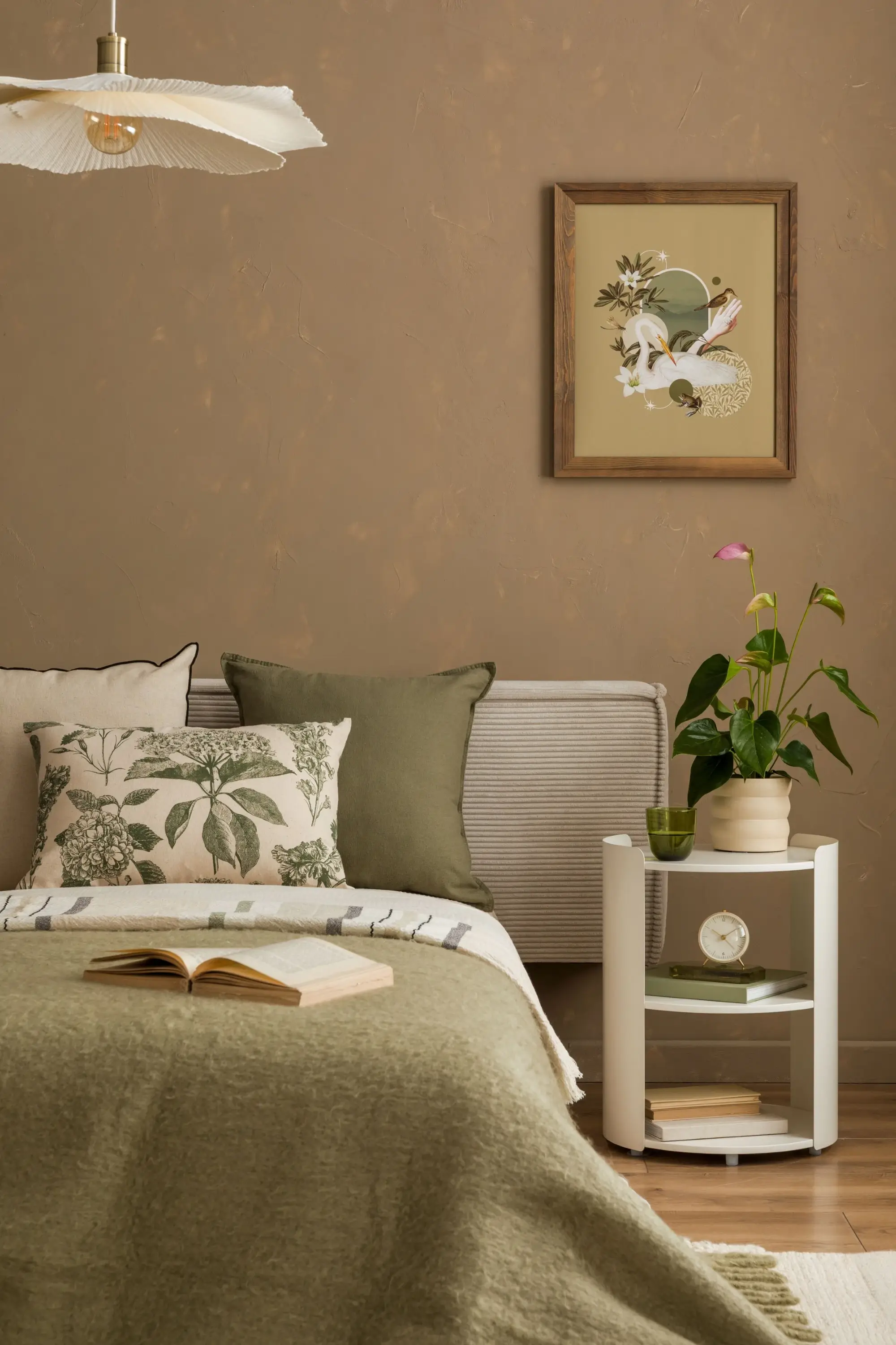 Schlafzimmer mit grün-beigen Kissen auf dem Bett.