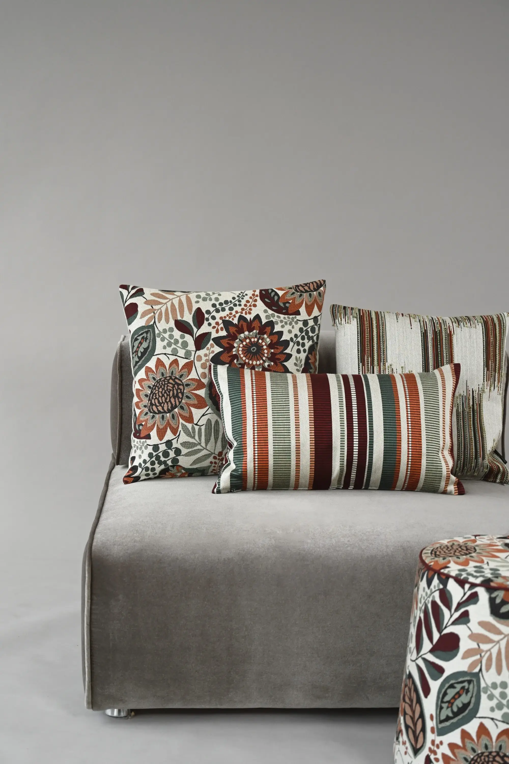 Sofa mit Kissen und Pouf der Botanicals-Kollektion von Rohleder im floralen und gestreiften Design.