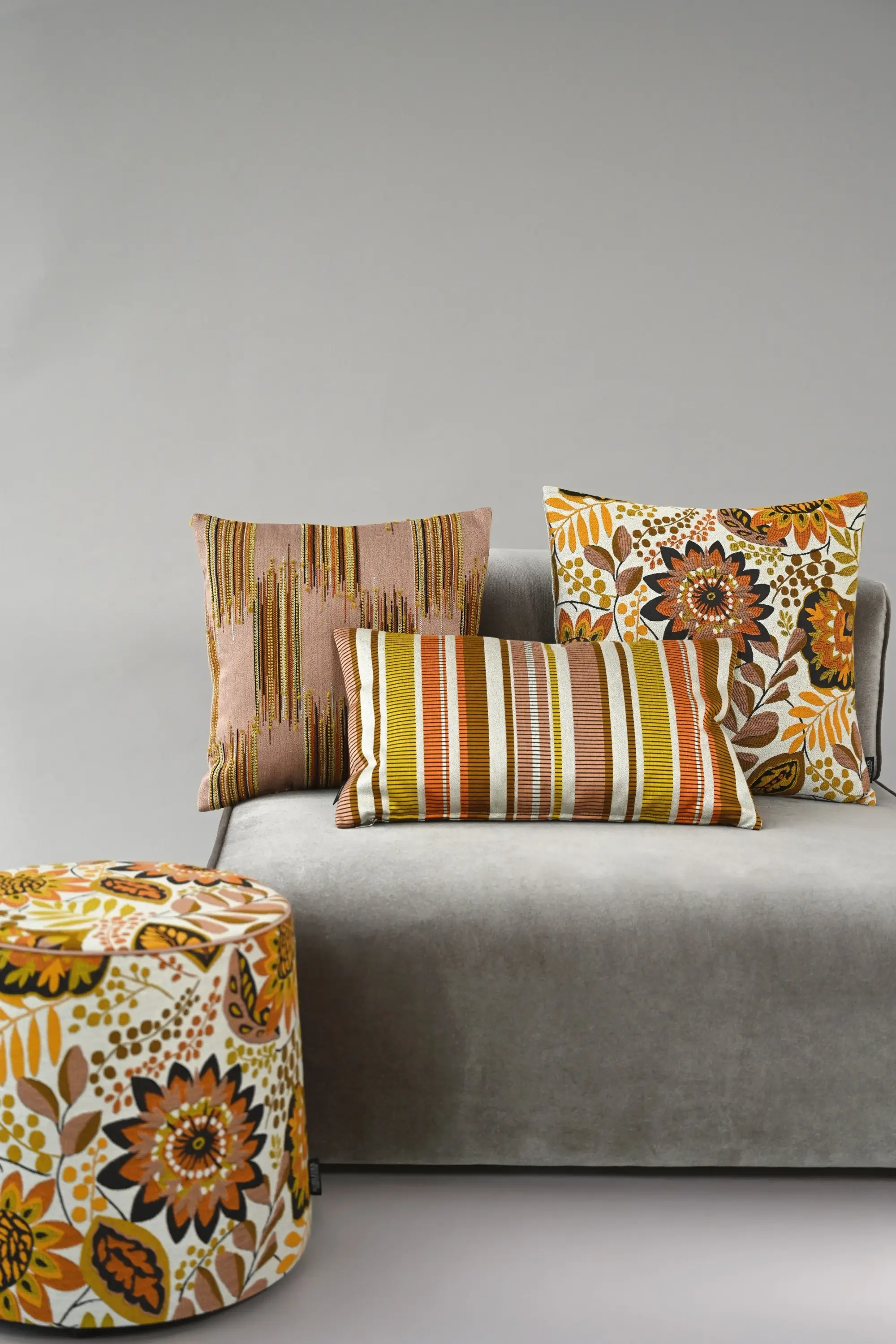 Sofa mit bunten Kissen und Pouf aus der Botanicals-Kollektion von Rohleder.