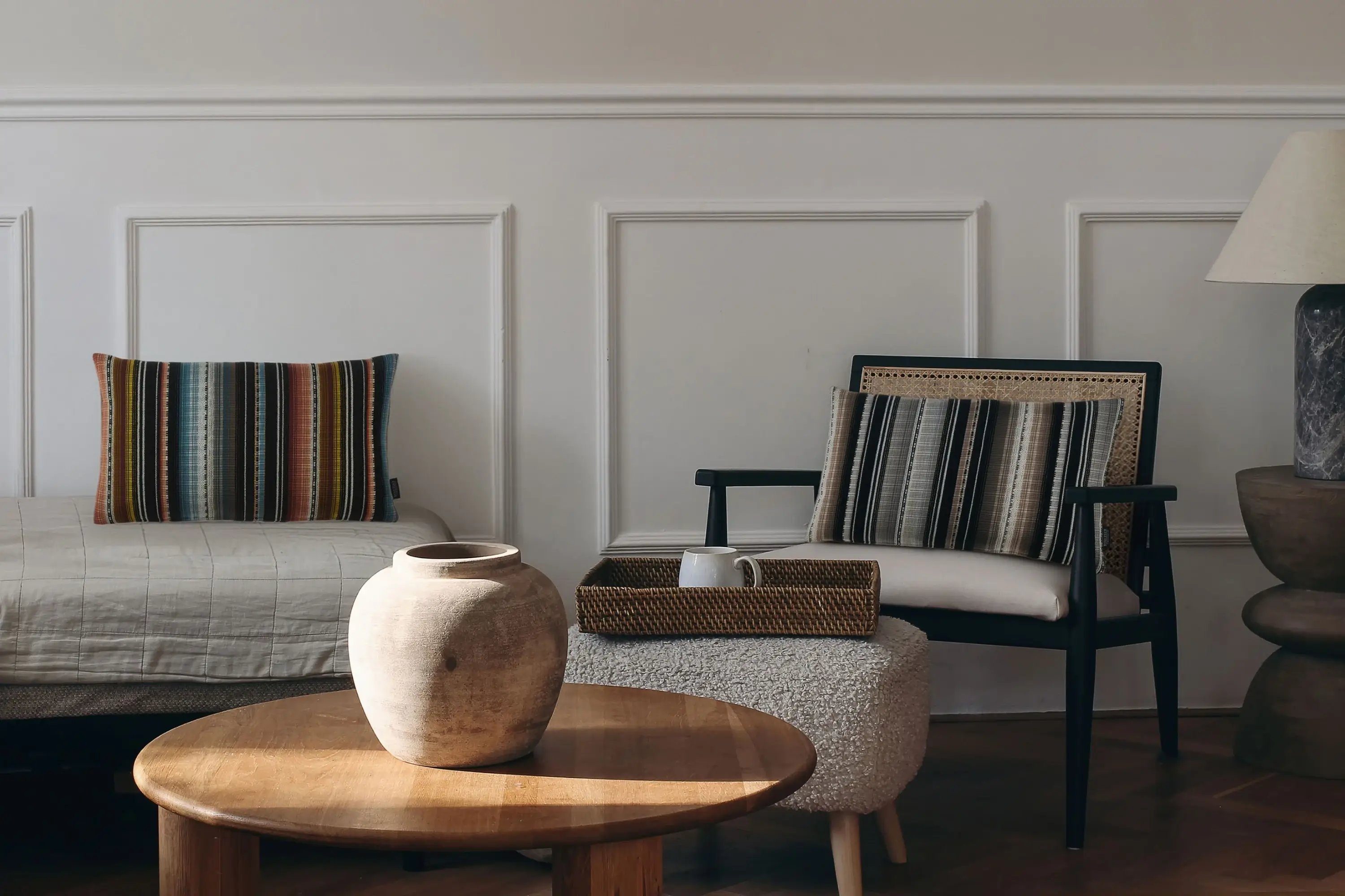 Gestreifte Kissen Maya aus der Tulum-Kollektion von Rohleder auf Sofa und Sessel.