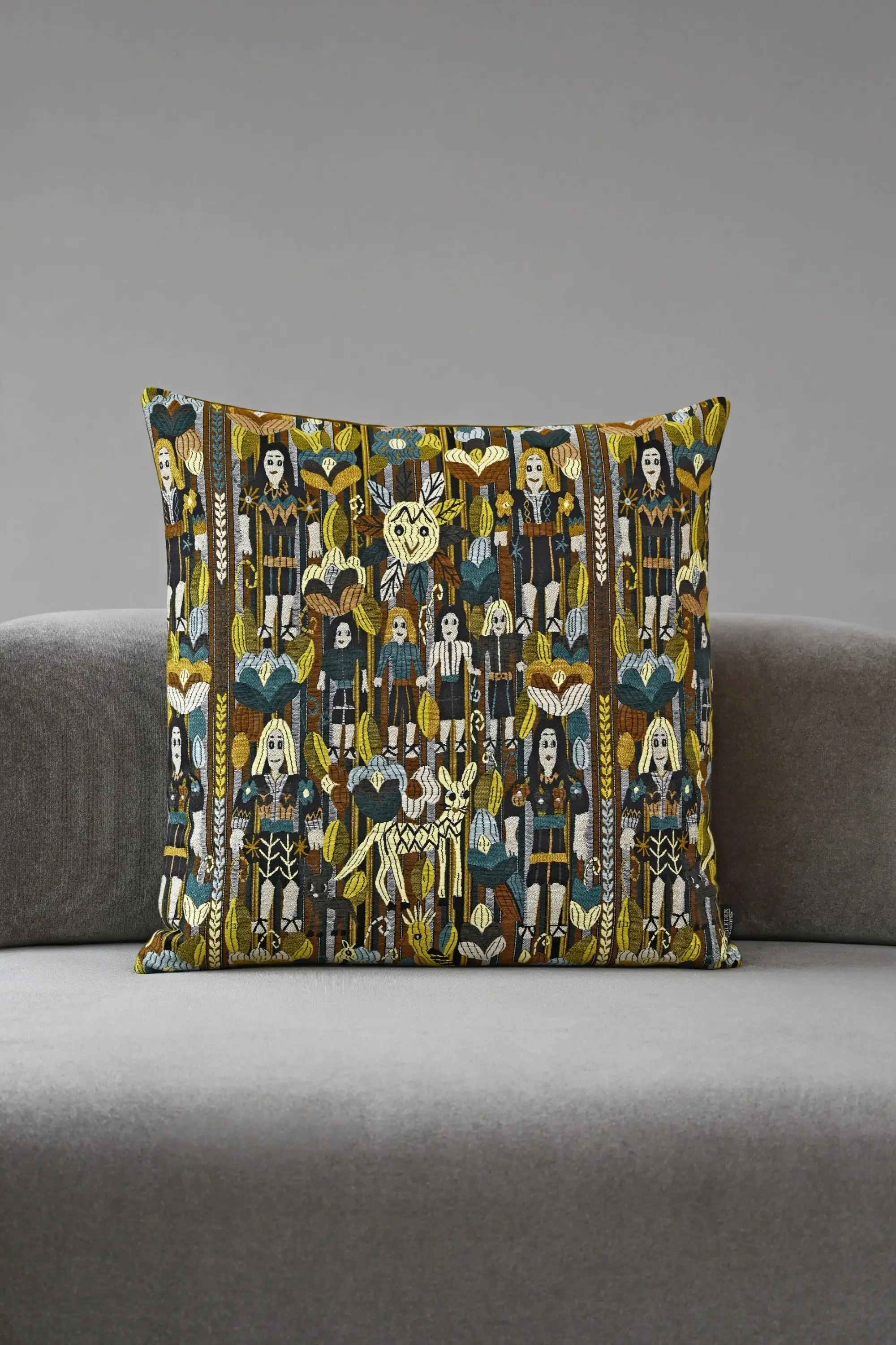 People-Kissen aus der Tulum-Kollektion von Rohleder auf grauem Sofa.